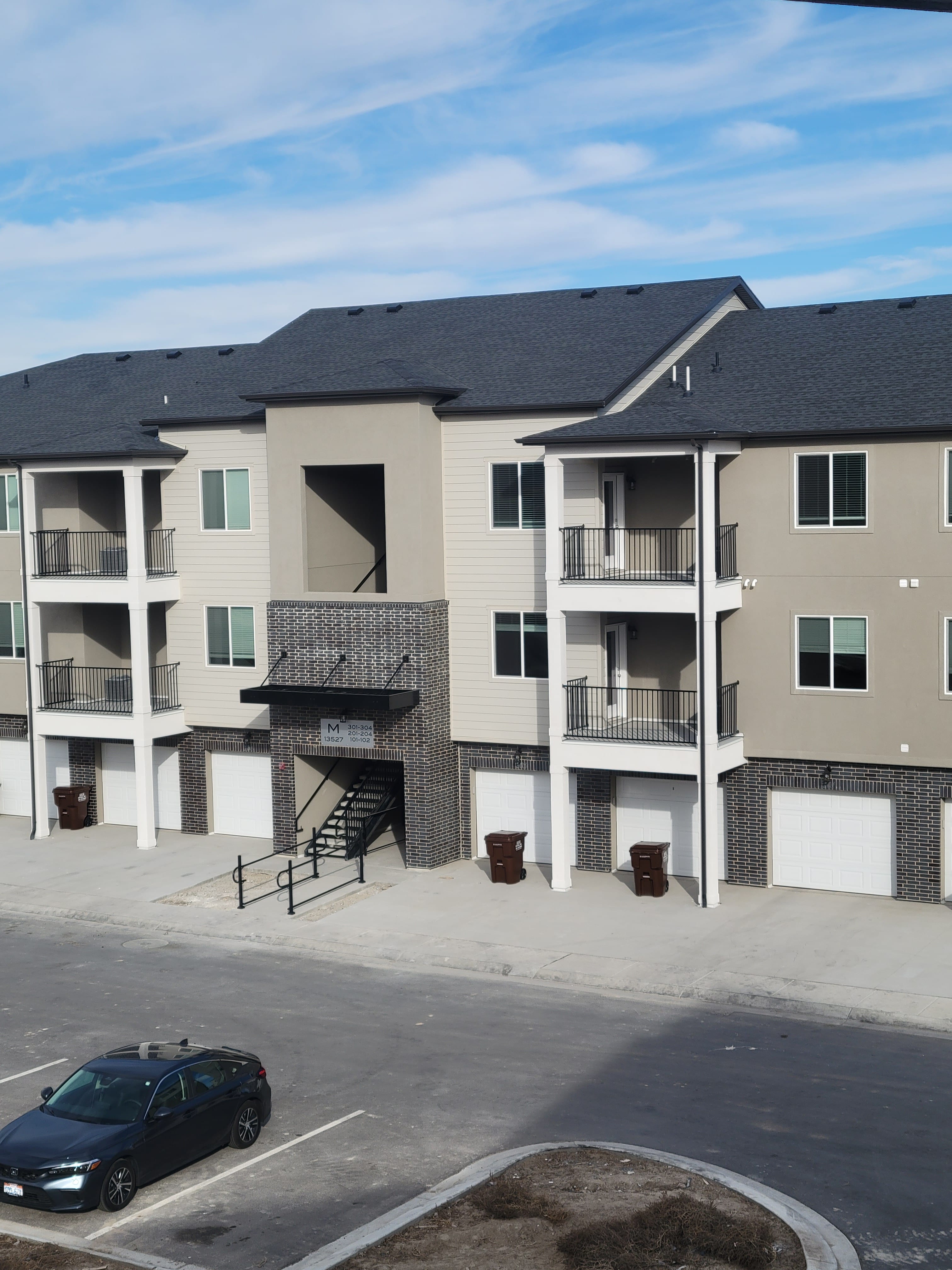 Apartment building with black railings along balconies and exterior entry stairs